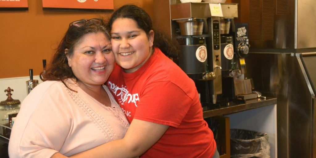 Evelyn Medina gets a hug from her daughter, Sascha, who has grown up in the business. 